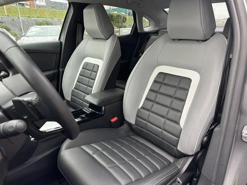 Vue intérieure rapprochée des sièges avant gris clair et noir du Citroën C4 X 2025, mettant en valeur leur design matelassé.