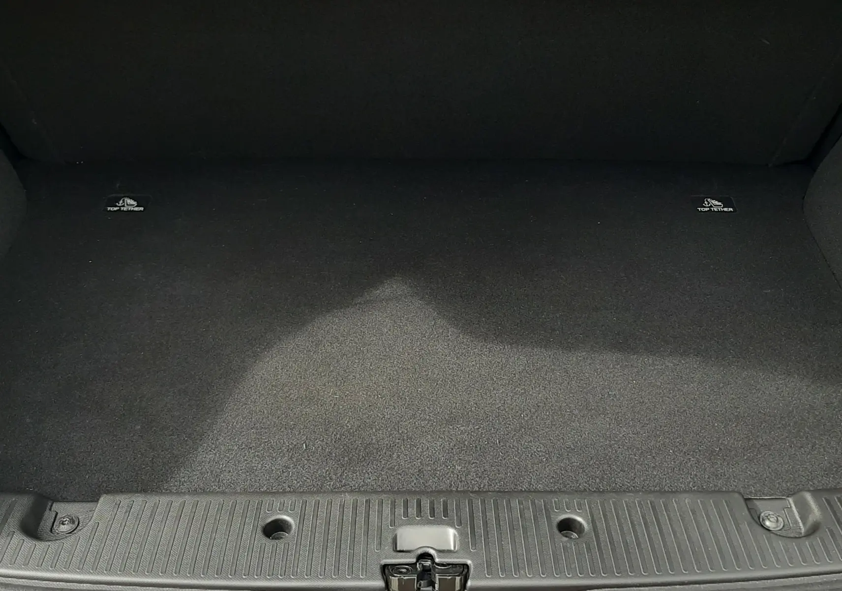 Coffre ouvert vu de face de la Renault Twingo III blanc cristal, montrant un espace de chargement propre et vide.