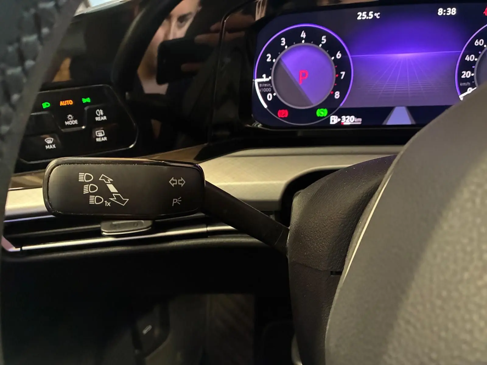 Vue rapprochée du combiné d'instruments et du commodo gauche d'une Volkswagen Golf gris clair 2023, affichage digital violet.