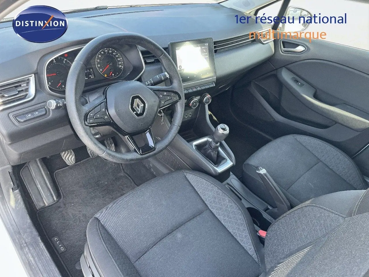 Vue intérieure côté conducteur de la Renault Clio Société 2020, avec volant multifonction et sièges tissu gris noir.