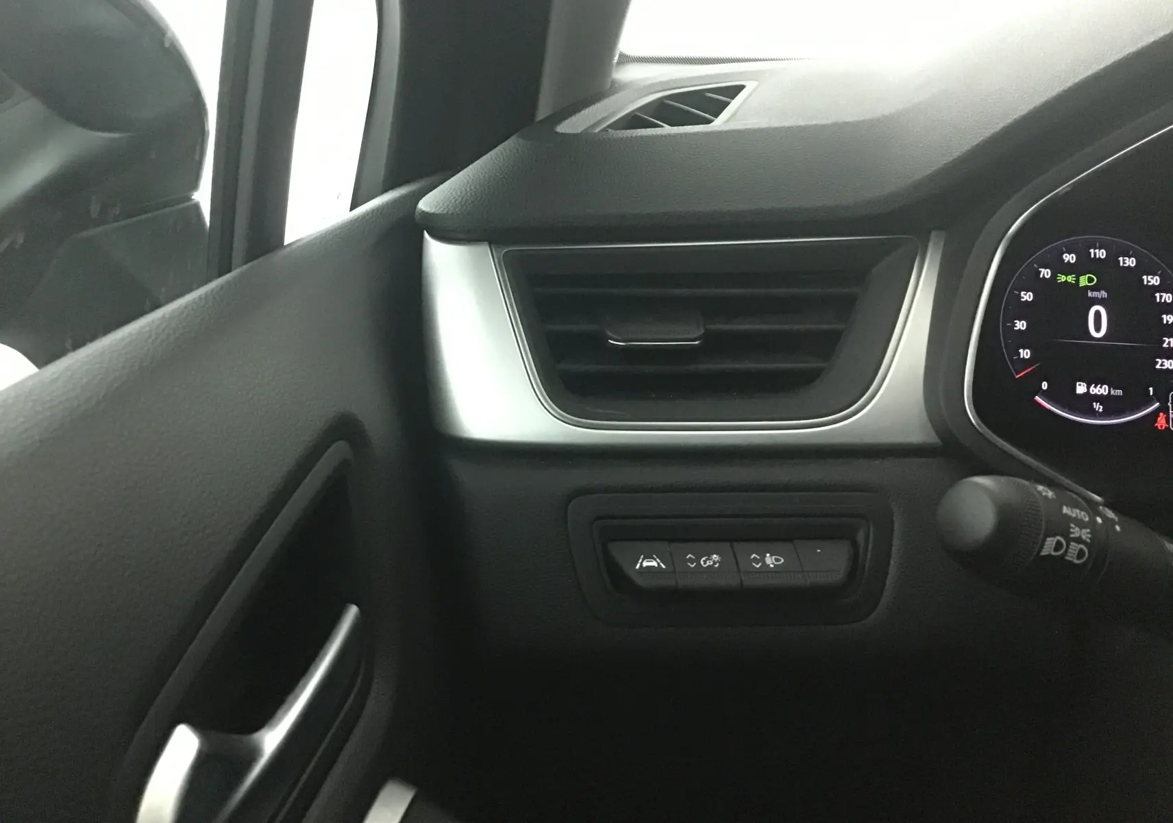 Détail du tableau de bord côté gauche du Renault Captur 2024 gris Cassiopée avec commandes d'assistance et compteur digital.
