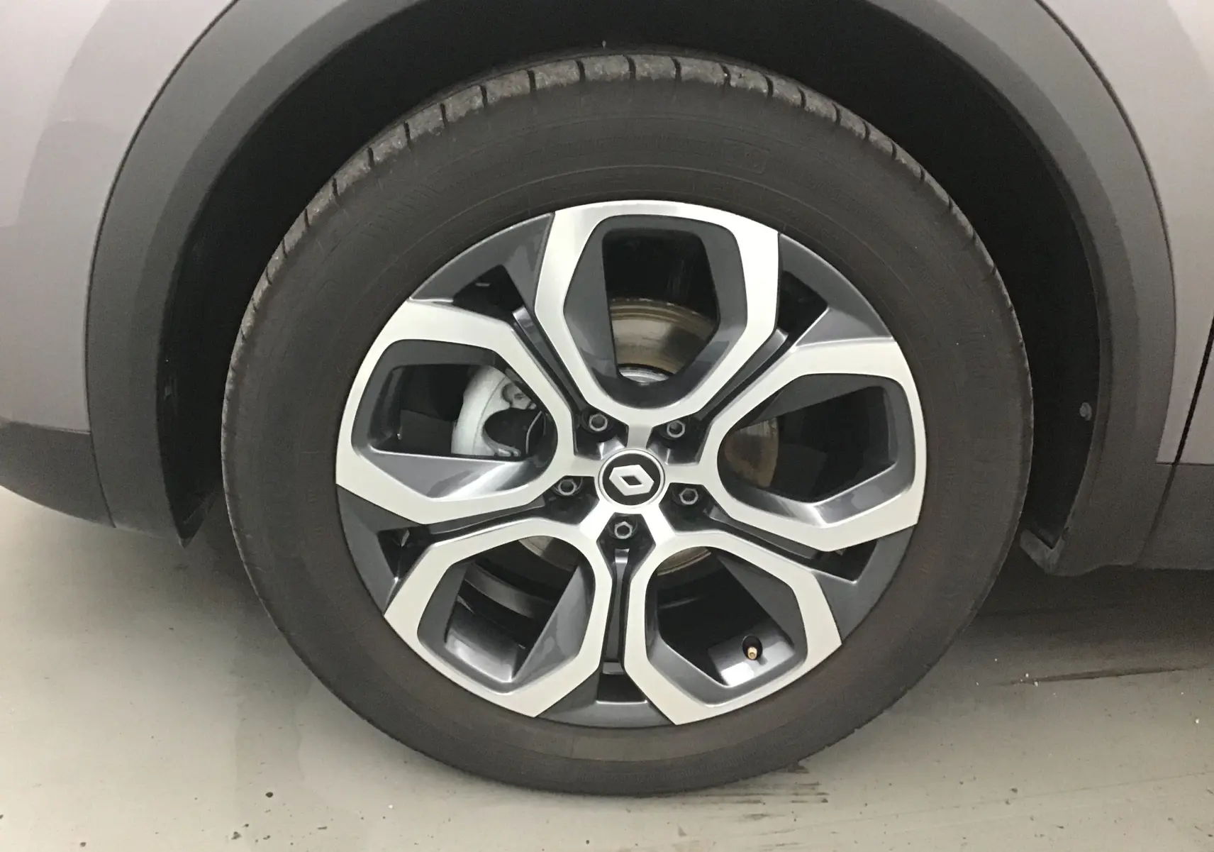 Gros plan sur la jante alliage 18 pouces du Renault Captur gris Cassiopée, mettant en valeur le design moderne et le logo central.