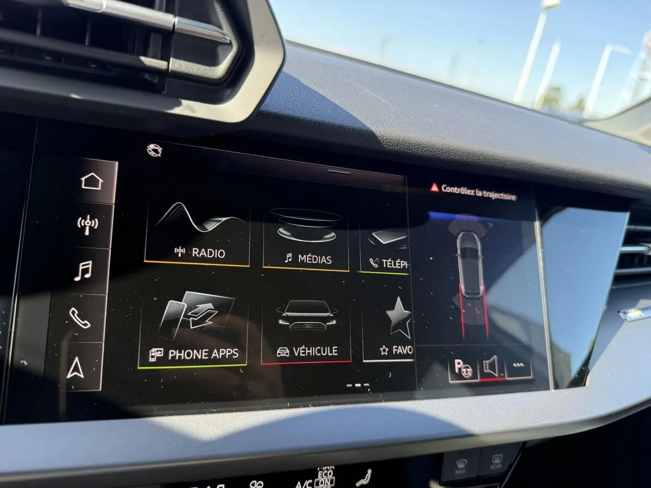 Écran tactile central de l'Audi A3 Sportback 2024 montrant l'interface multimédia et l'assistance au stationnement.
