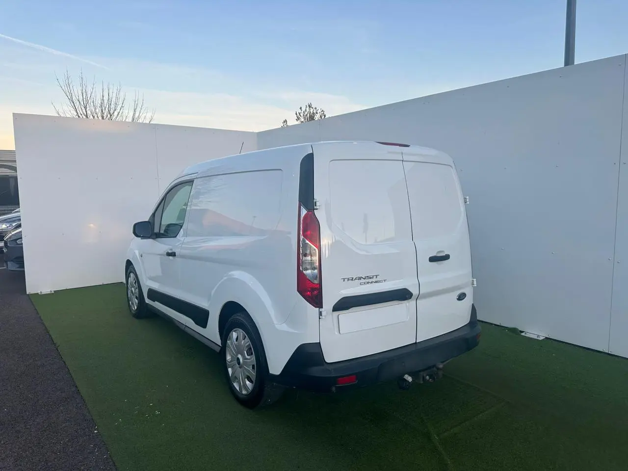 Ford Transit Connect blanc vu en 3/4 arrière droit avec porte latérale coulissante et attelage visible