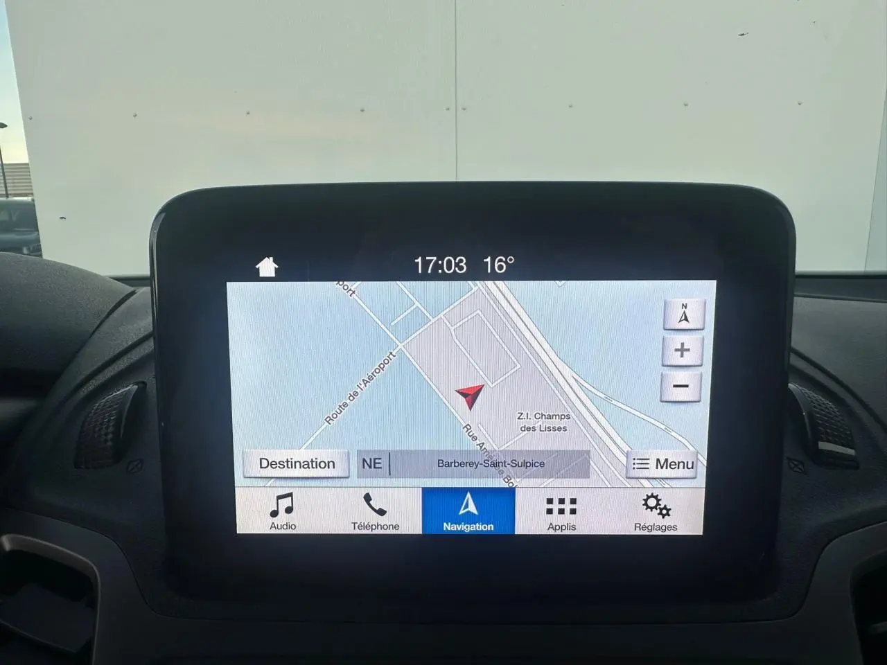 Écran tactile central du tableau de bord du Ford Transit Connect blanc, affichant la navigation GPS en extérieur.