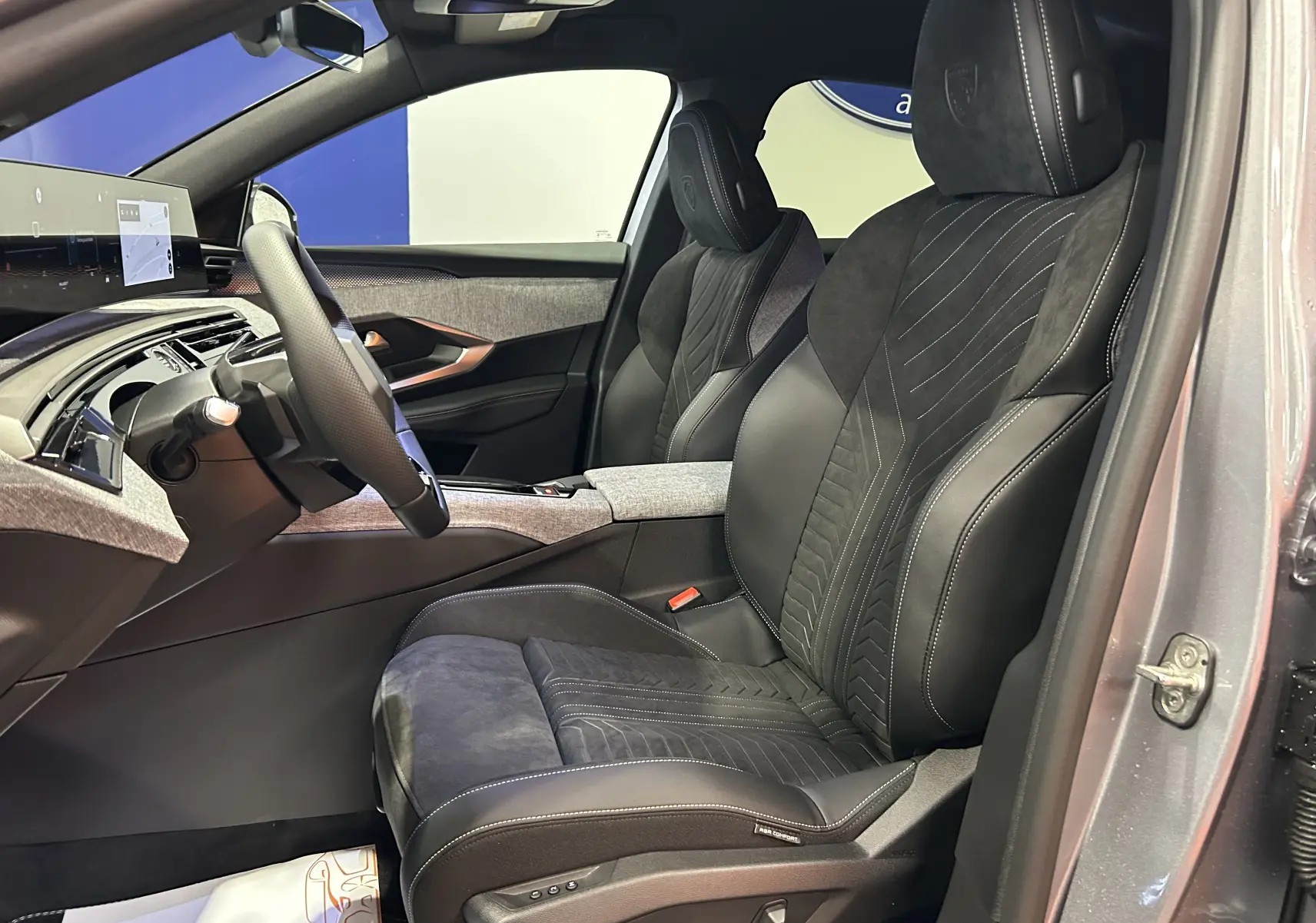 Vue intérieure côté gauche du Peugeot 3008 gris Artense, mettant en valeur les sièges avant en Alcantara noir avec surpiqûres blanches et réglages électriques.