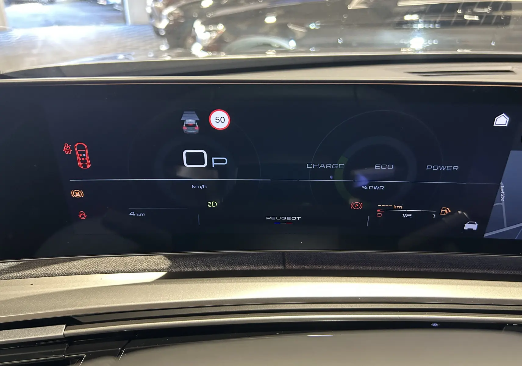 Vue rapprochée du tableau de bord numérique du Peugeot 3008 gris Artense, affichant les indicateurs de conduite et navigation.