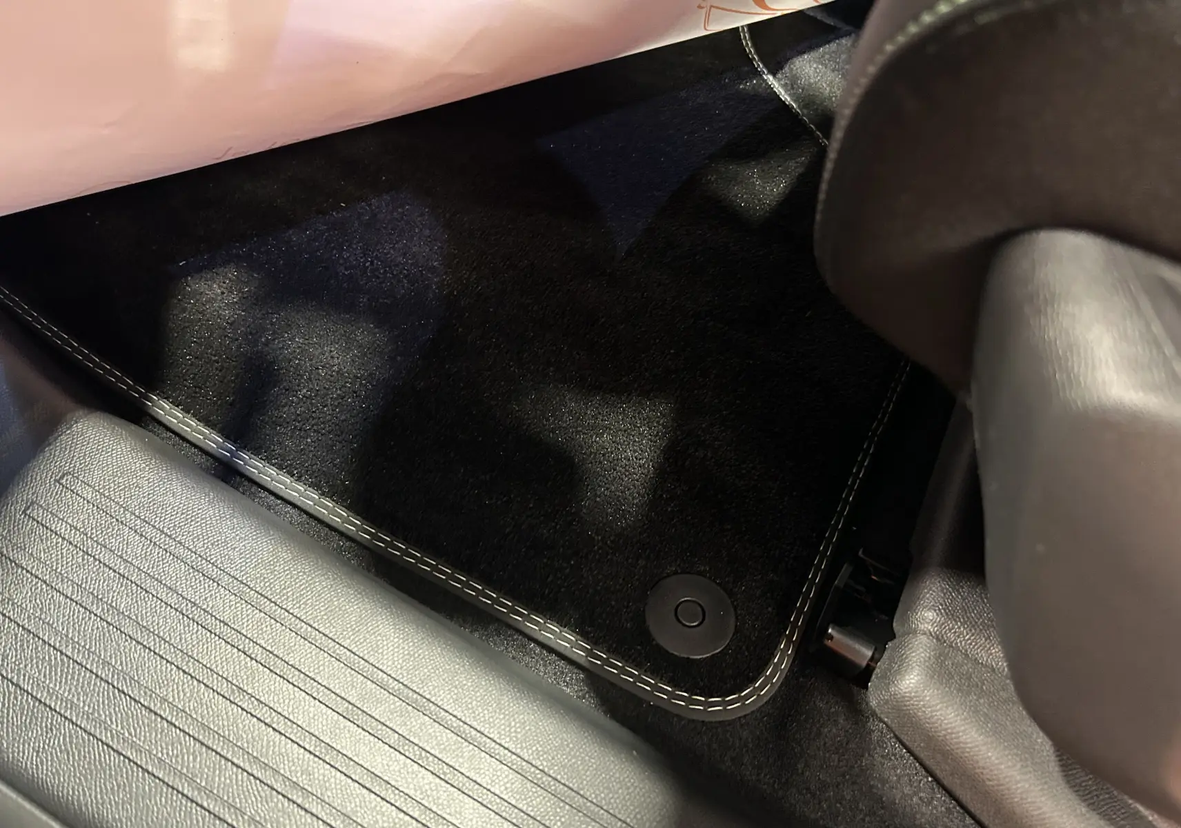 Gros plan sur le tapis de sol noir avec surpiqûres blanches côté conducteur du Peugeot 3008 gris Artense 2025.