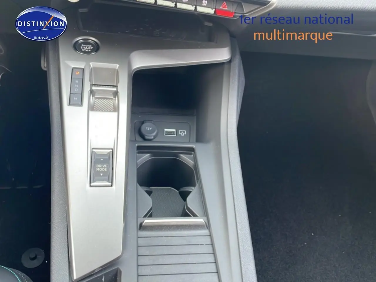 Vue rapprochée de la console centrale noire de la Peugeot 308 1.2 hybrid 145 allure e-dcs6 avec commandes de boîte auto.