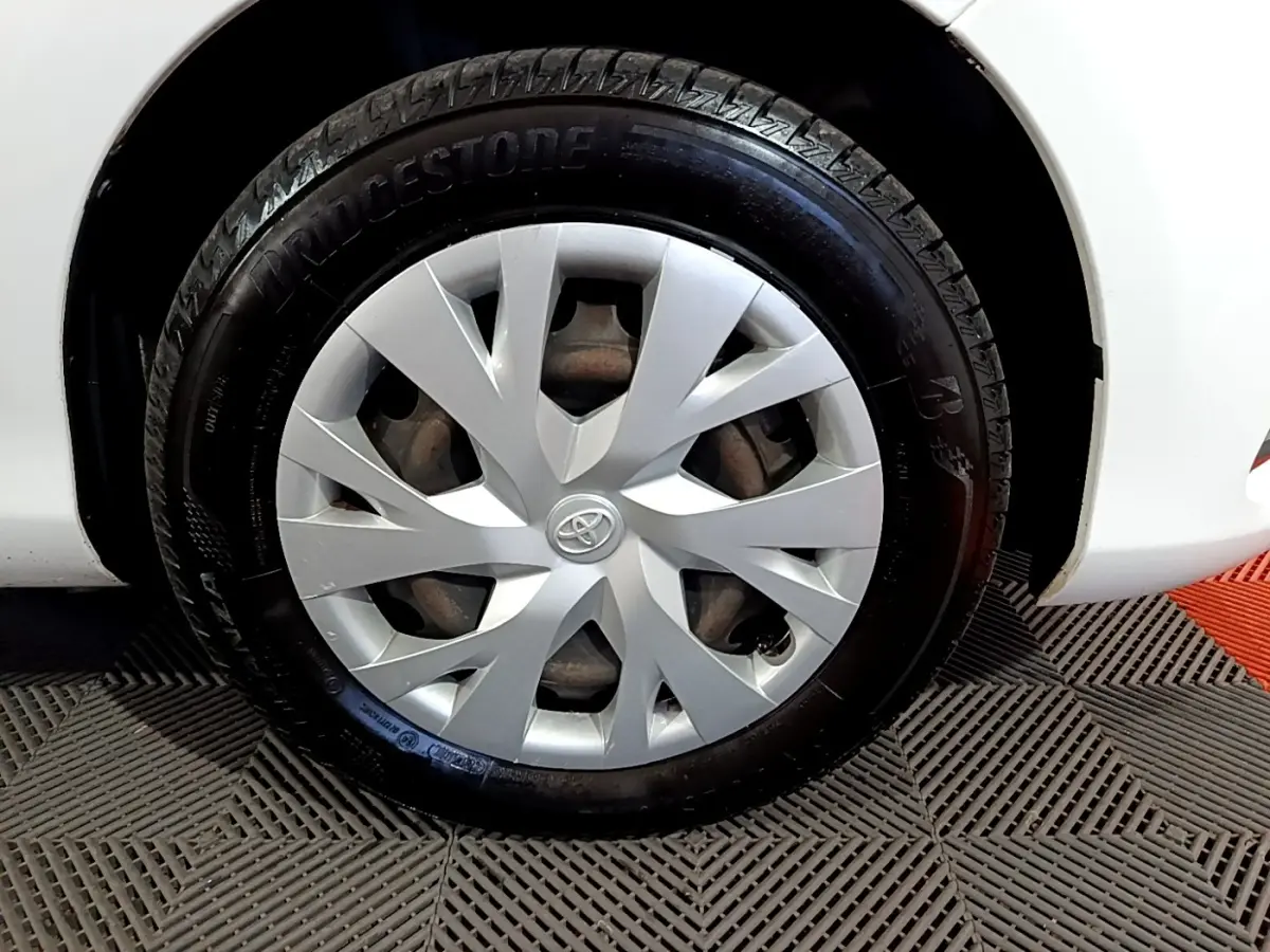 Gros plan sur la roue avant droite blanche de la Toyota Yaris 1.5 Hybride 2020 avec enjoliveur argenté et pneu Bridgestone.