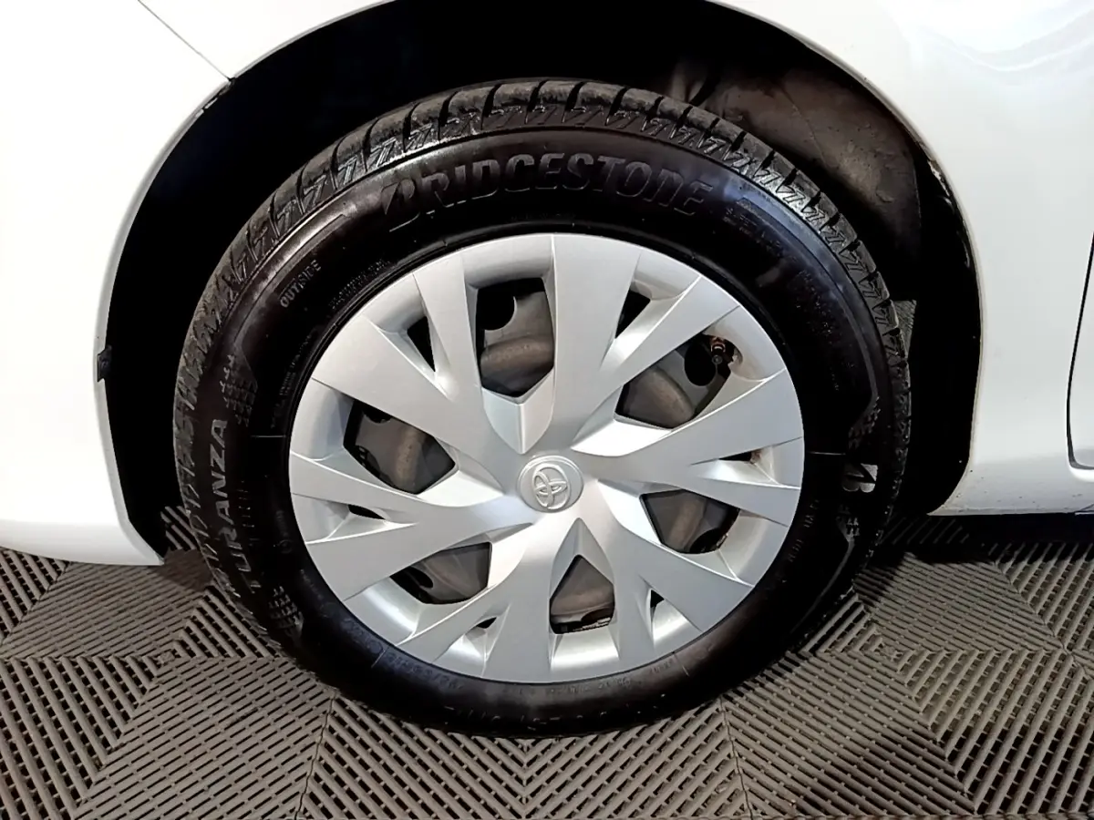 Gros plan sur la roue avant droite blanche d'une Toyota Yaris 1.5 Hybride avec enjoliveur argenté et pneu Bridgestone.