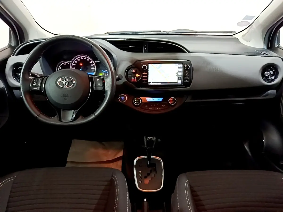 Vue intérieure avant de la Toyota Yaris 1.5 Hybride 2020, tableau de bord avec écran tactile et volant cuir alu multifonctions.