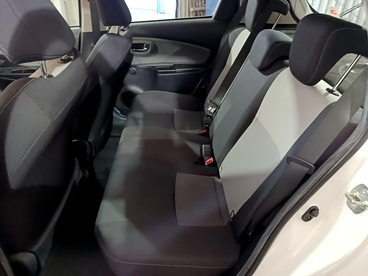 Vue intérieure côté droit des sièges arrière bicolores gris et noir de la Toyota Yaris 1.5 Hybride 2020 blanche.