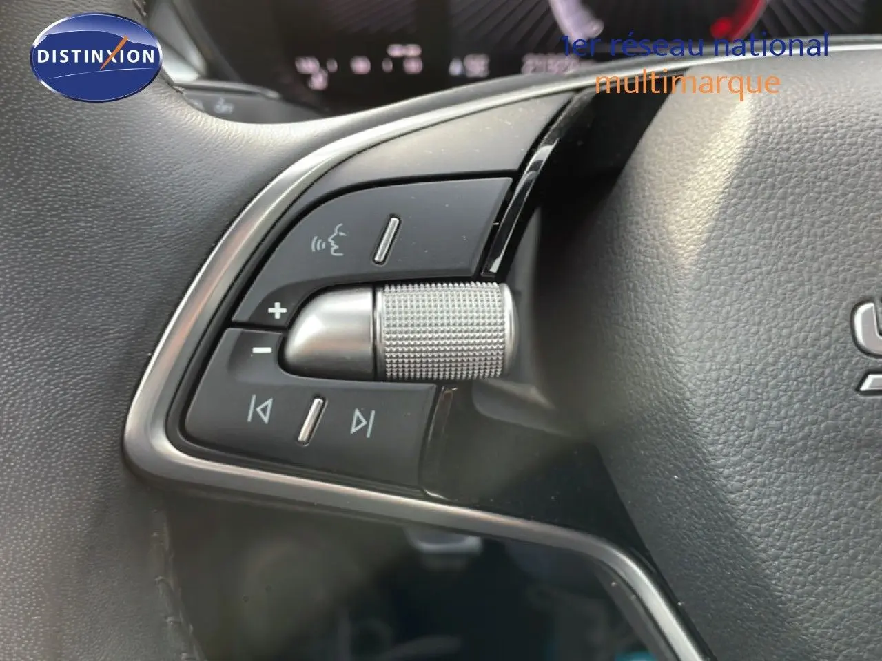 Gros plan sur les commandes audio au volant côté gauche de la Skoda Fabia blanc glacier 2025.
