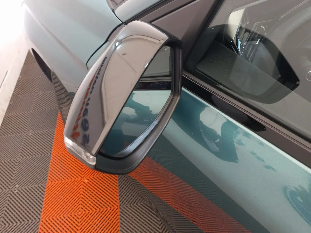 Rétroviseur droit rabattable électriquement sur Peugeot 308 bleu, vue rapprochée côté conducteur.