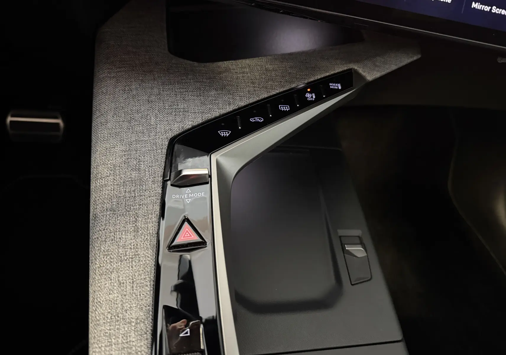Gros plan sur la console centrale du Peugeot 3008 Hybrid 145 GT 2025, avec sellerie tissu gris et commandes tactiles noires.