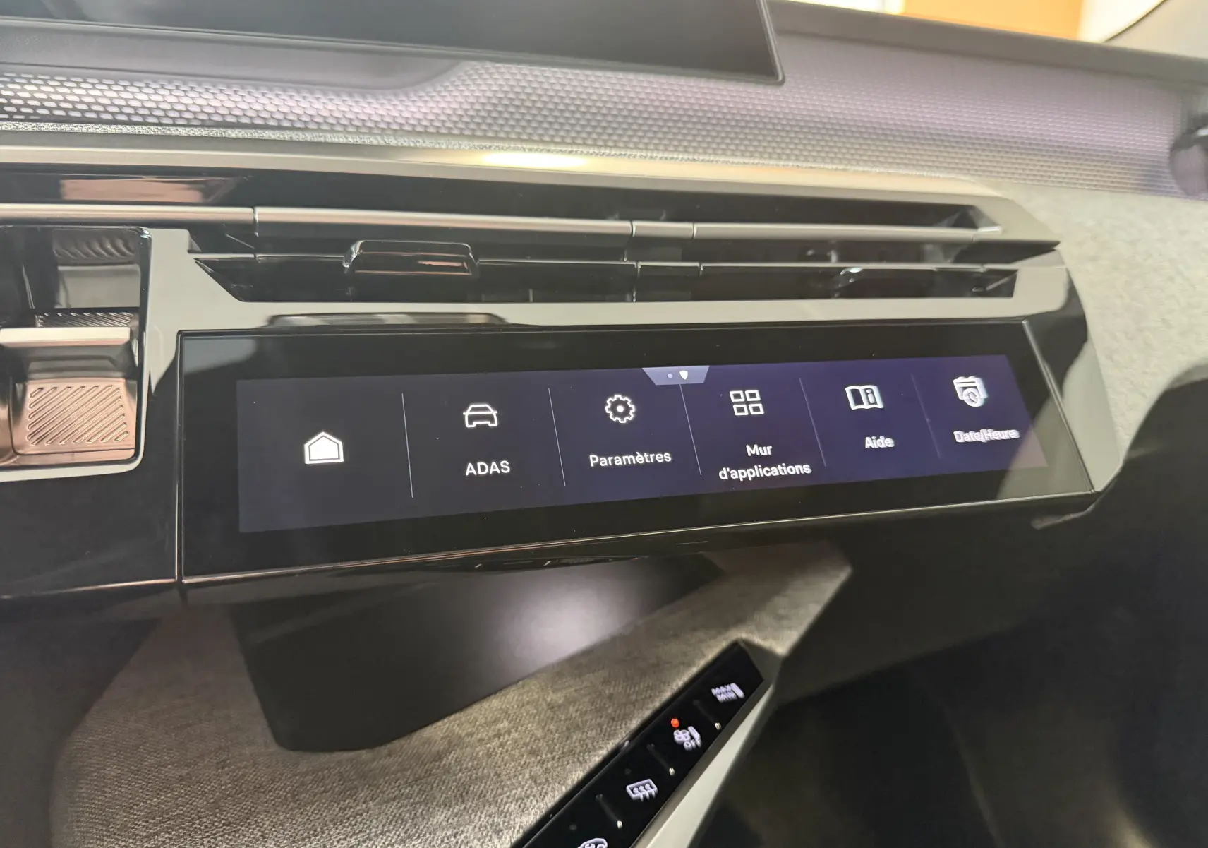 Vue rapprochée de la console centrale tactile du Peugeot 3008 Hybrid 145 GT, avec finition noire et détails tissu gris.