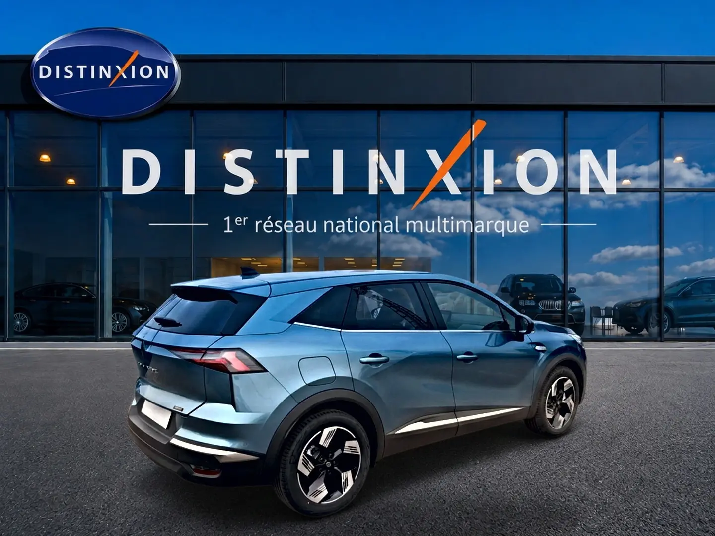 Renault Symbioz bleu mercure en 3/4 arrière droit, avec jantes alliage et toit noir devant showroom Distinxion.