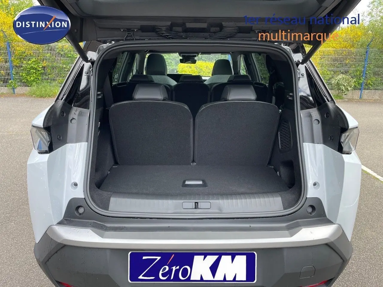 Vue arrière ouverte du Peugeot 5008 hybride blanc Okenite avec toit noir, montrant le coffre et les sièges arrière.