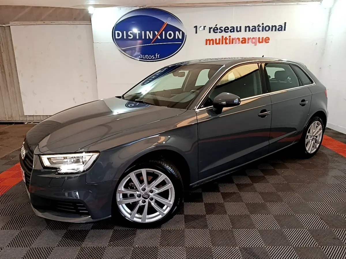 Audi A3 30 TDI gris foncé vue 3/4 avant droit en intérieur avec jantes alliage et phares LED allumés.
