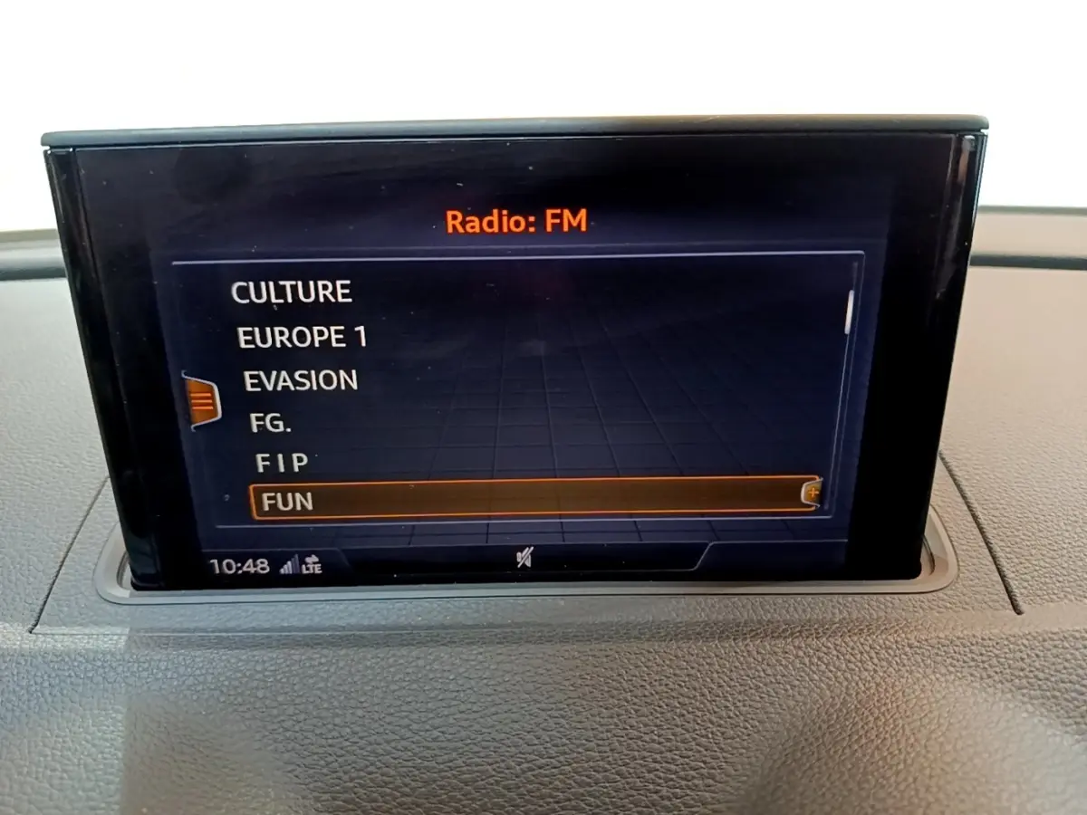 Écran central de l'Audi A3 30 TDI 2019 affichant la liste des stations radio FM, vue intérieure frontale.