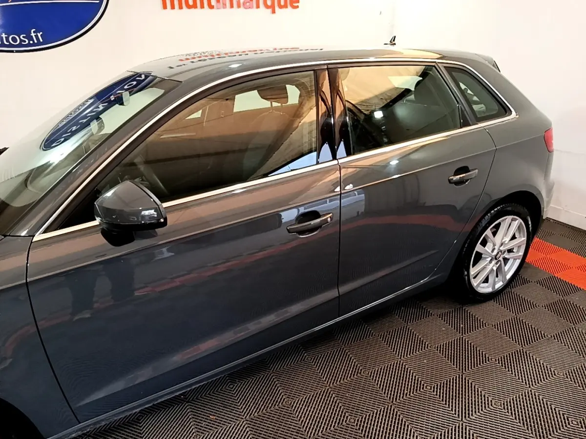 Vue latérale droite d'une Audi A3 gris foncé 2019, mettant en valeur les jantes alliage et les rétroviseurs électriques.