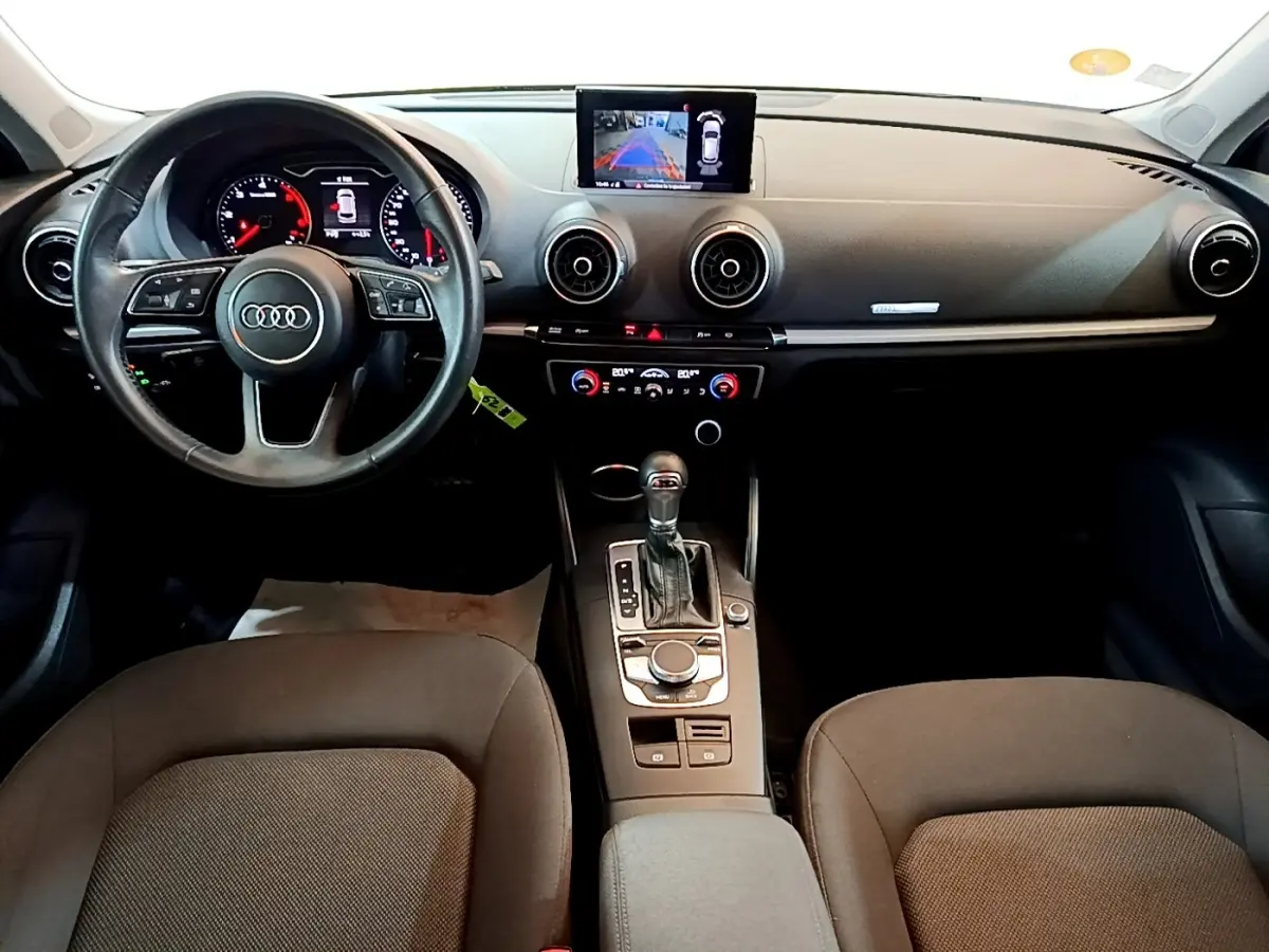 Vue intérieure avant de l'Audi A3 30 TDI Business Line 2019, volant cuir multifonctions et écran central affichant la caméra de recul.