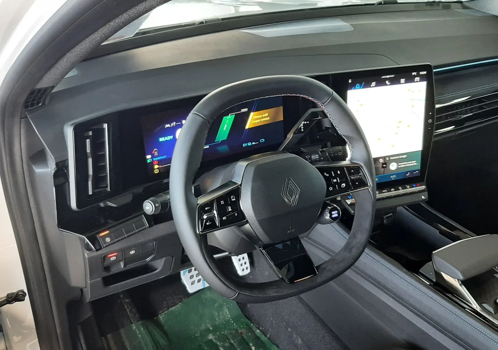 Vue intérieure côté conducteur du Renault Austral 2025, volant multifonction et grand écran tactile vertical.