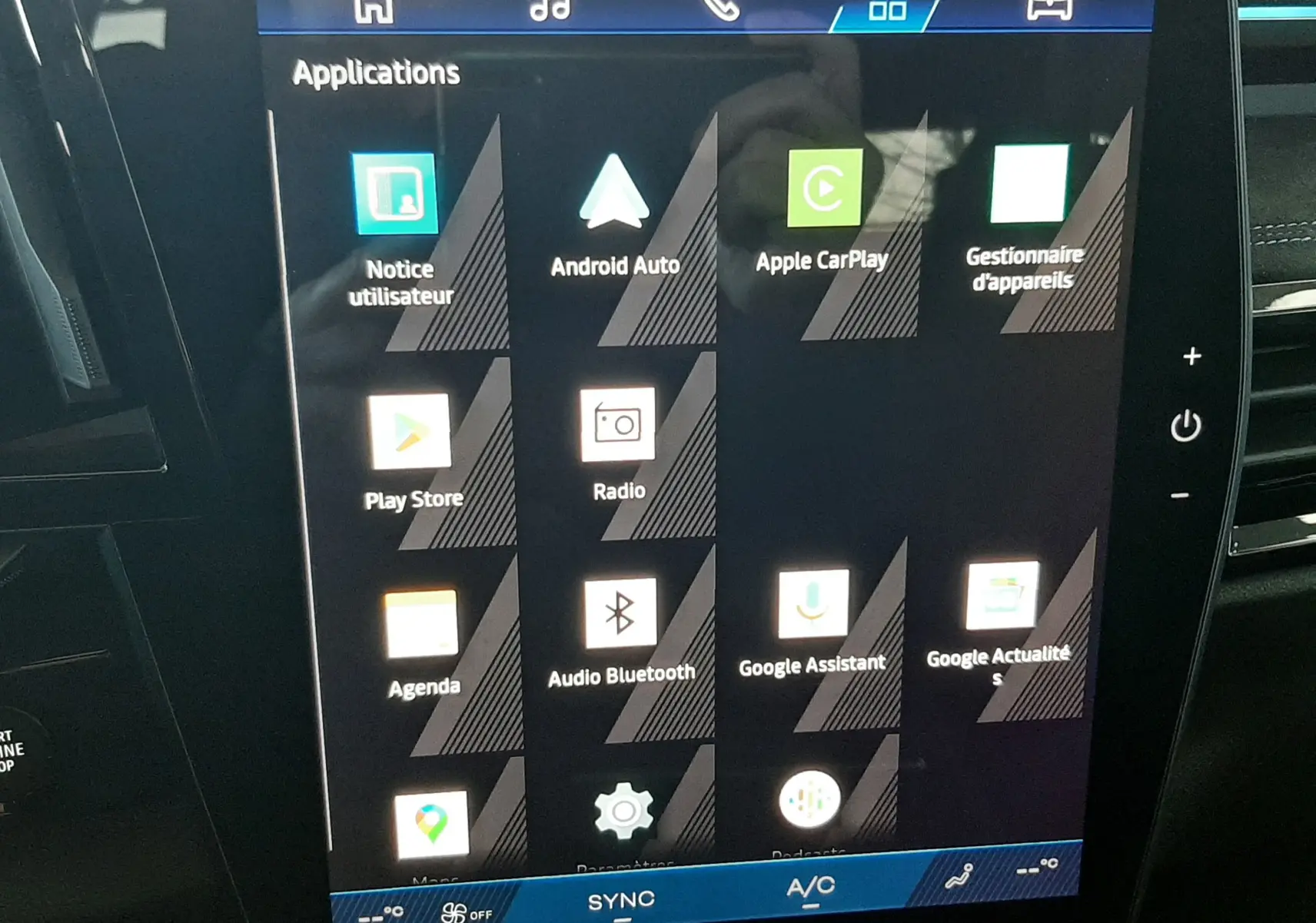Écran tactile central de la Renault Austral 2025 affichant les applications connectées, dans un intérieur noir.