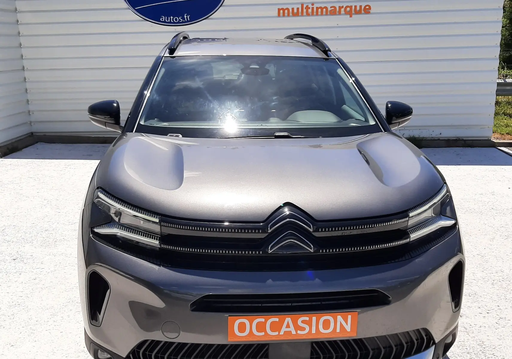 Vue avant d'un Citroën C5 Aircross hybride gris platinium, avec calandre distinctive et plaque "OCCASION" orange.