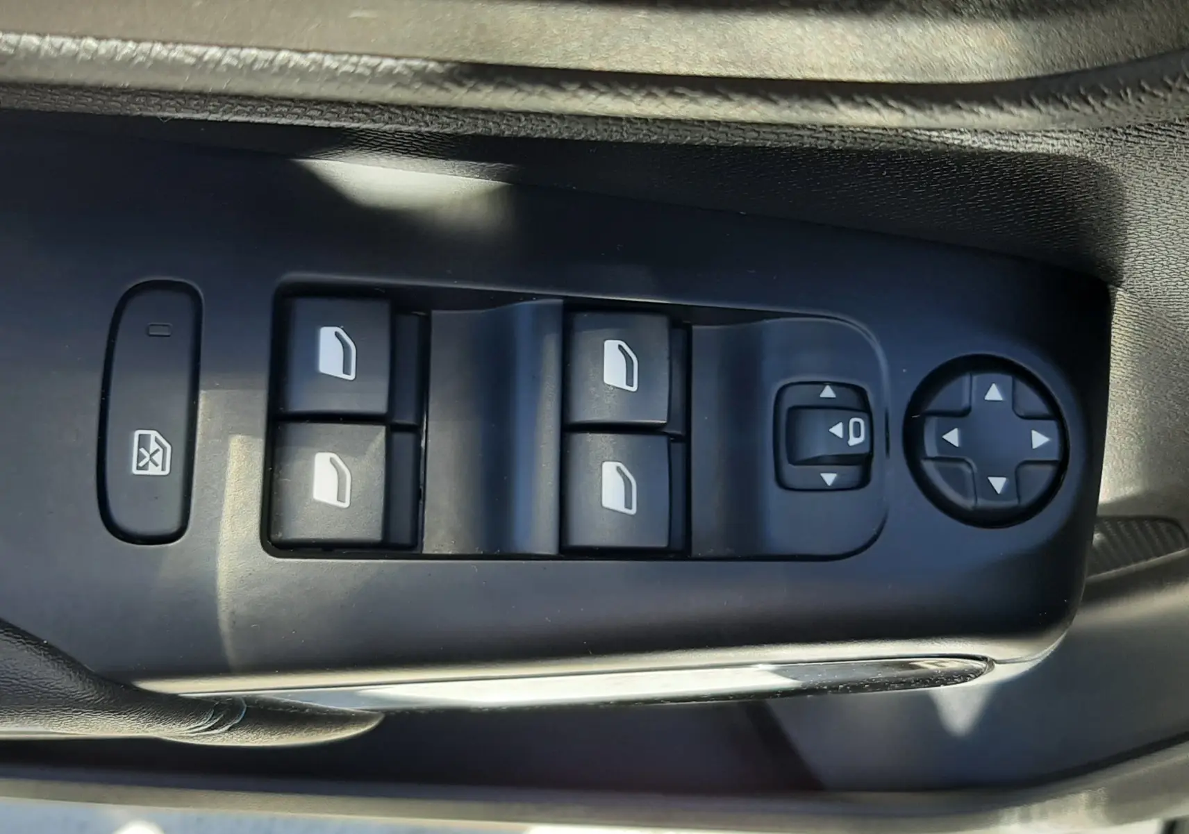 Gros plan sur les commandes de lève-vitres et réglages des rétroviseurs côté conducteur du Citroën C5 Aircross gris platinium 2025.