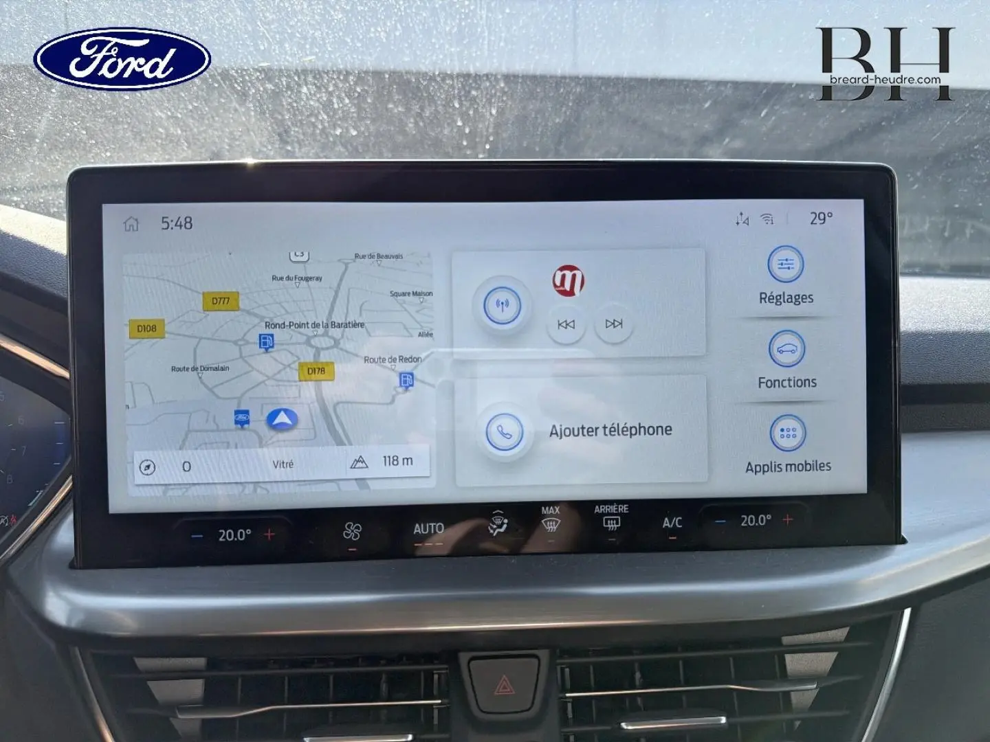 Écran tactile central de navigation et commandes climatisation dans Ford Focus gris Lunaire, vue de face intérieure.