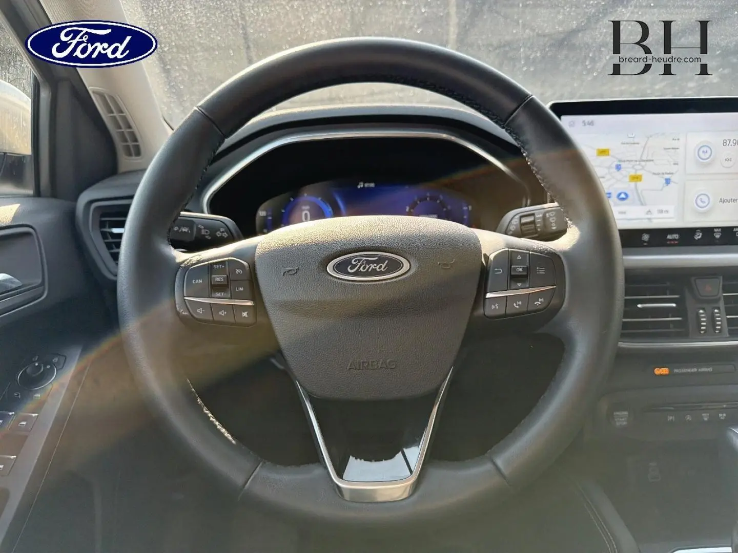 Vue rapprochée du volant cuir multifonction de la Ford Focus 2023 avec tableau de bord numérique et écran tactile.