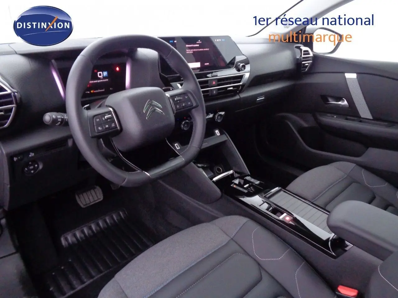 Intérieur de la Citroën C4 X 2023, vue du poste de conduite côté gauche, avec tableau de bord numérique et console centrale noire brillante.