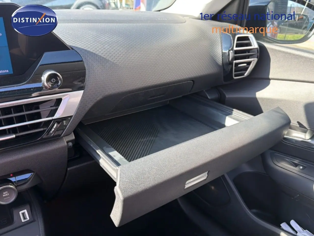 Intérieur de la Citroën C4 X 2023, vue côté passager sur la boîte à gants ouverte et tableau de bord noir.