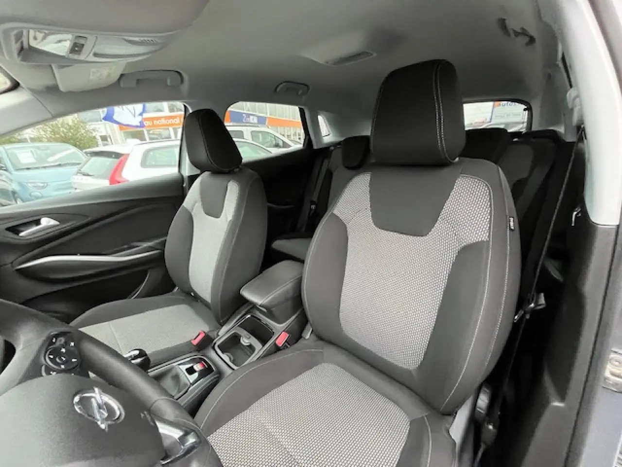 Vue intérieure côté conducteur de l'Opel Grandland X 2019 avec sièges bi-matière gris et noir.