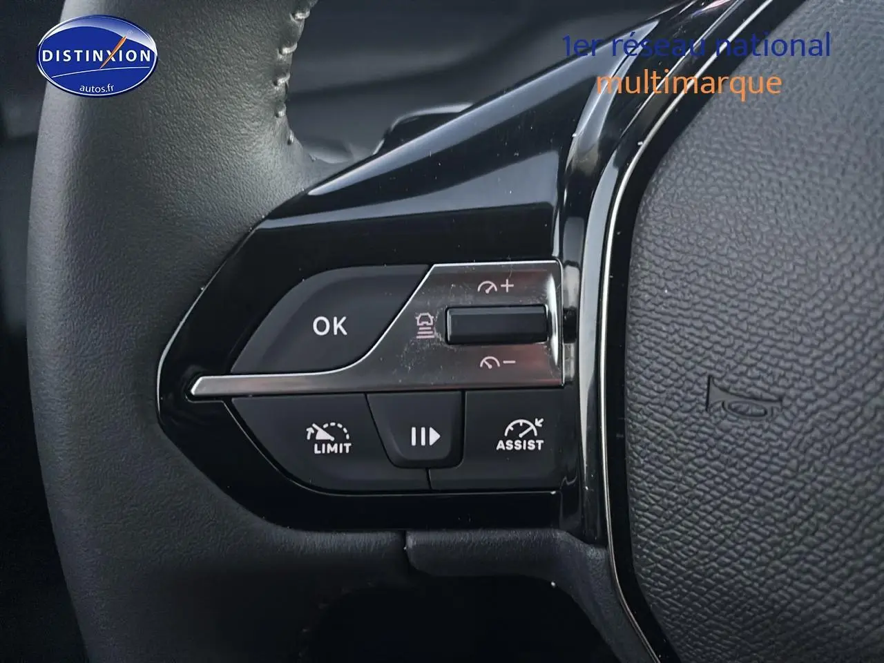 Gros plan sur les commandes de régulateur de vitesse au volant noir de la Peugeot 308 gris artense 2025.