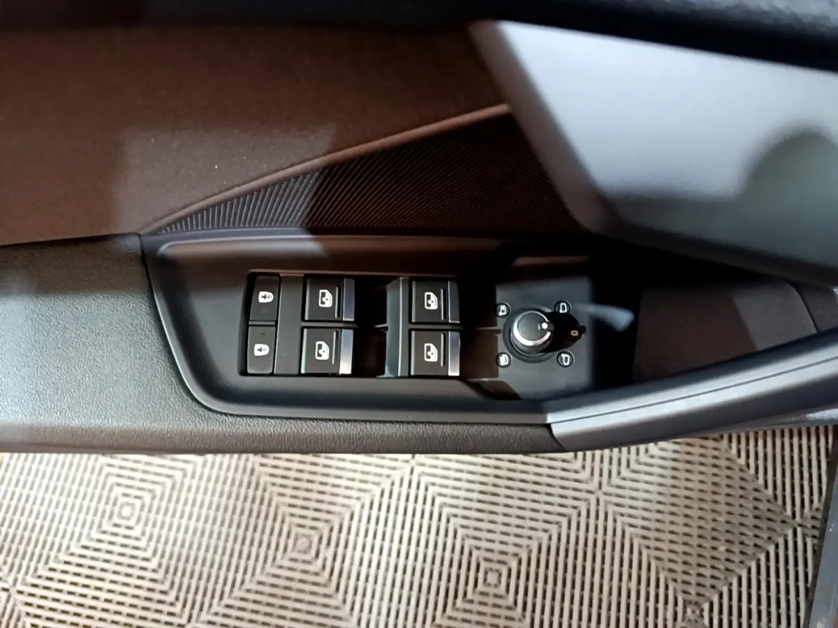 Vue rapprochée du panneau de commandes des vitres et rétroviseurs côté conducteur de l'Audi A3 gris foncé.