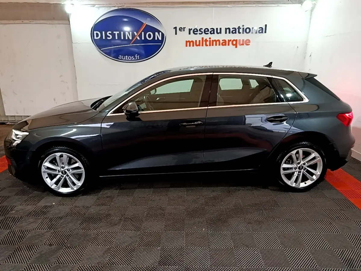 Profil côté gauche d'une Audi A3 gris foncé 2021, version 35 TFSI MHEV, dans un showroom intérieur.