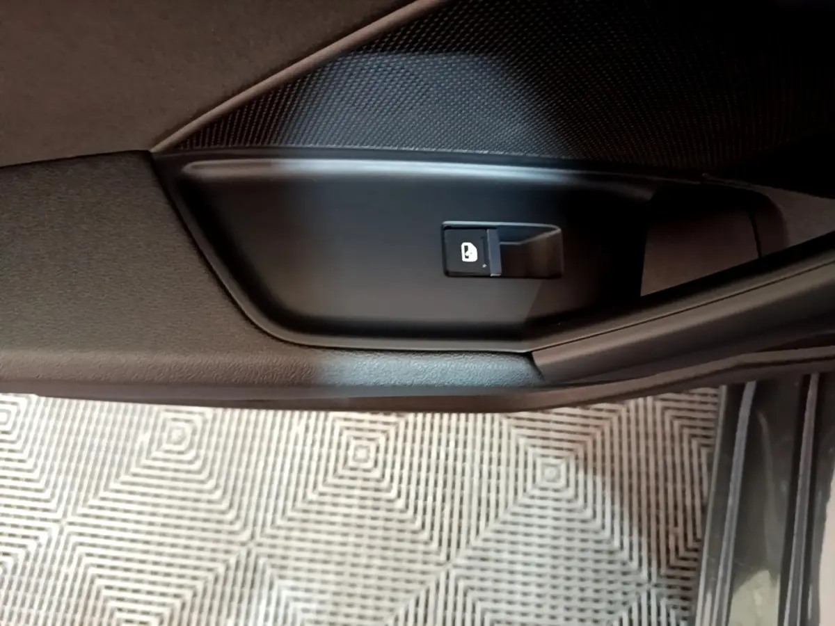 Détail de la commande de verrouillage de porte côté intérieur d’une Audi A3 gris foncé, vue rapprochée.
