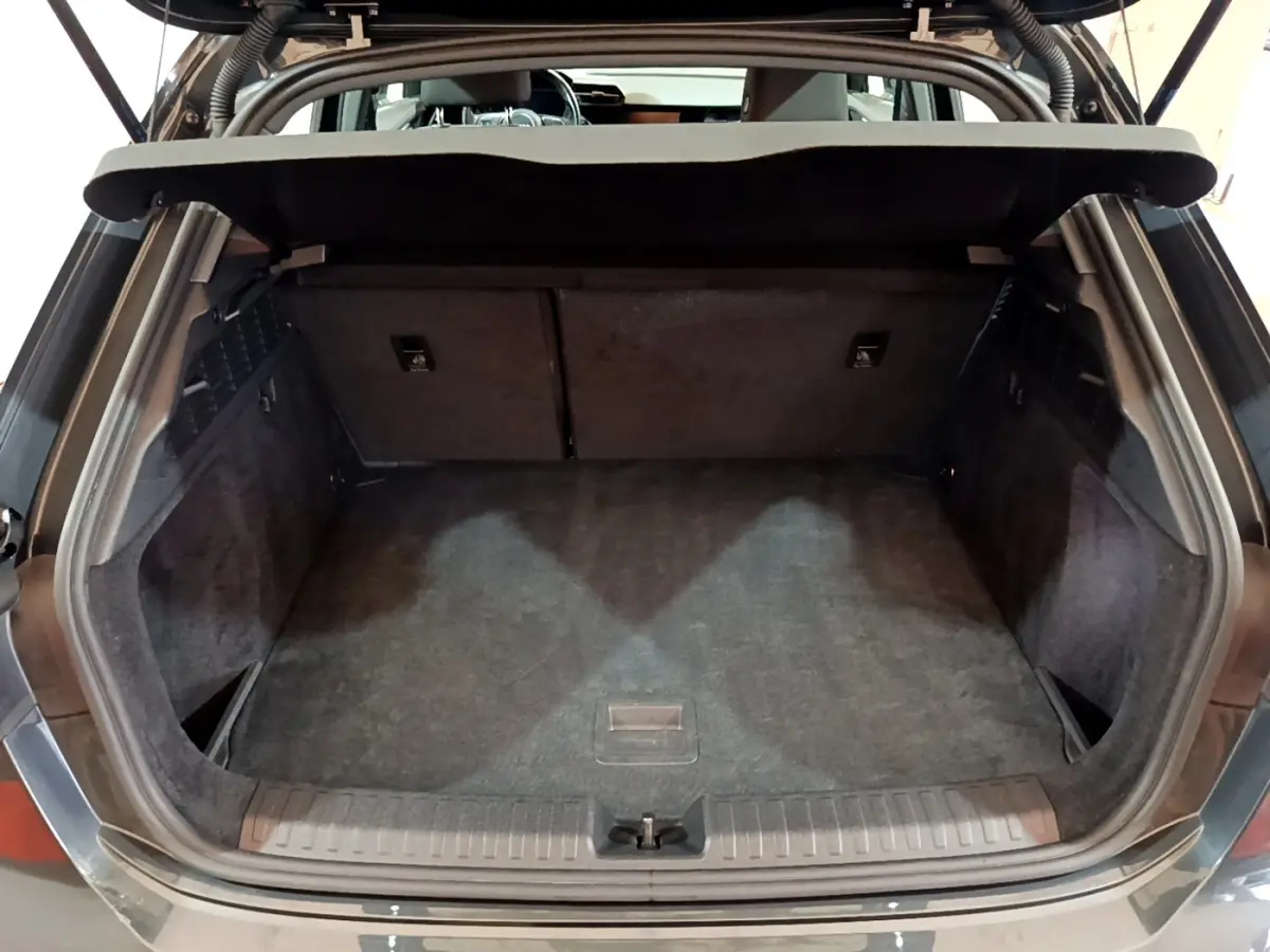 Vue arrière du coffre ouvert d'une Audi A3 gris foncé, montrant un espace de chargement propre et spacieux.
