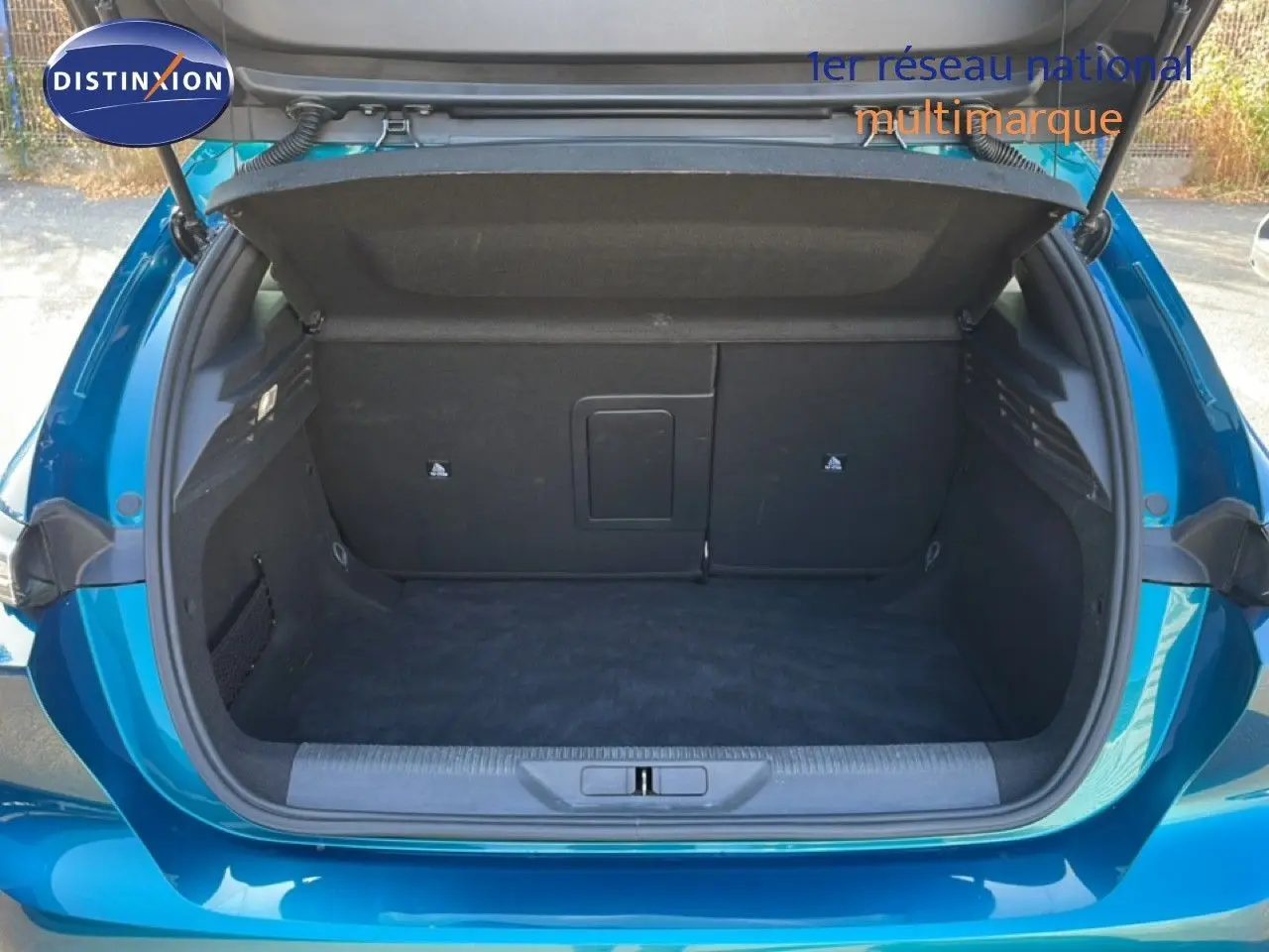 Coffre ouvert vu de l'arrière d'une Peugeot 308 1.2 PureTech 130ch Allure bleu obsession métal, espace de rangement vide.