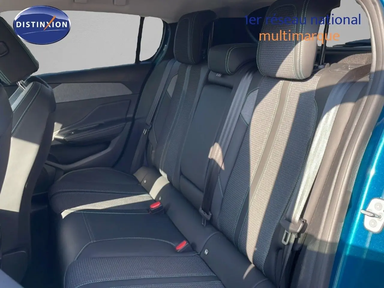 Vue intérieure côté droit des sièges arrière en tissu gris et cuir noir d'une Peugeot 308 Bleu Obsession 2024.