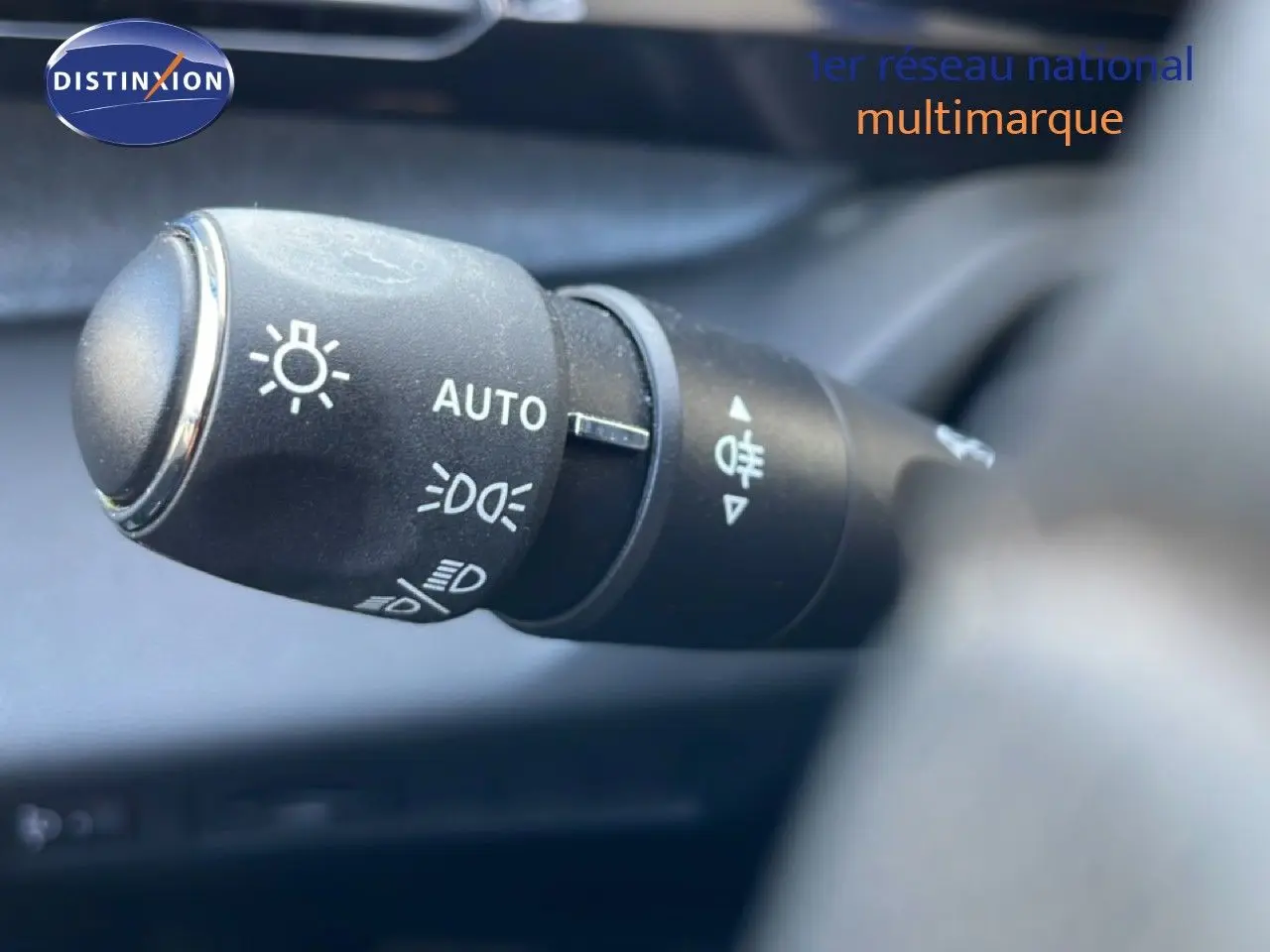Gros plan sur la commande des phares automatiques dans l’habitacle d’une Peugeot 308 Bleu Obsession 2024.