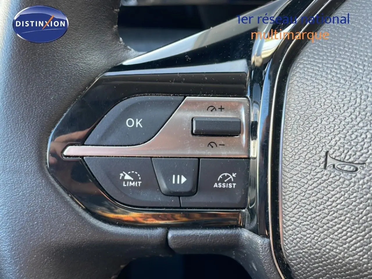 Gros plan sur les commandes au volant noir de la Peugeot 308 1.2 PureTech 130ch Allure, boutons OK, limiteur et assist.