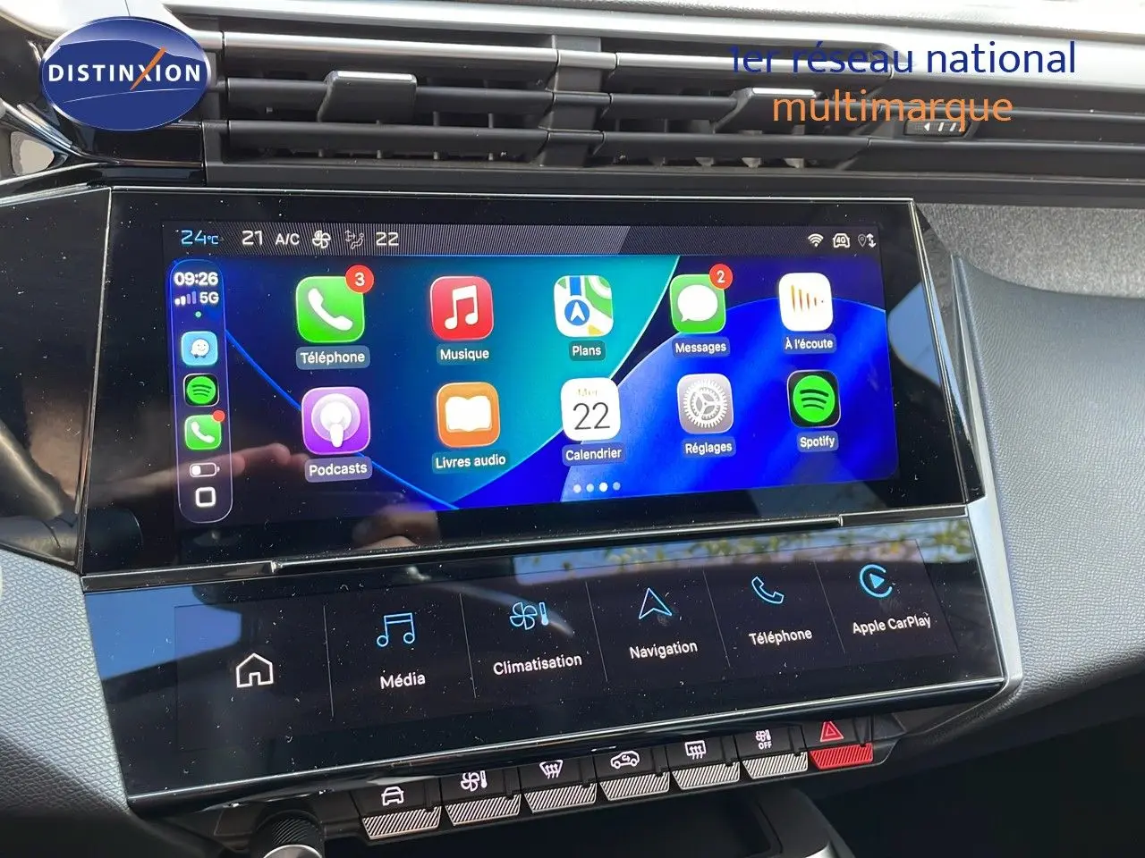 Écran tactile central de la Peugeot 308 2024 bleu obsession, affichant Apple CarPlay et commandes climatisation.