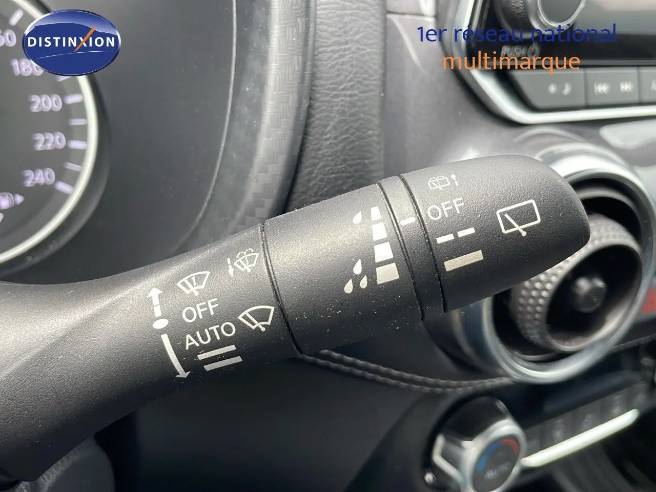 Gros plan sur la commande d'essuie-glace du Nissan Juke Hybrid 2023, avec détails des réglages visibles en intérieur noir.