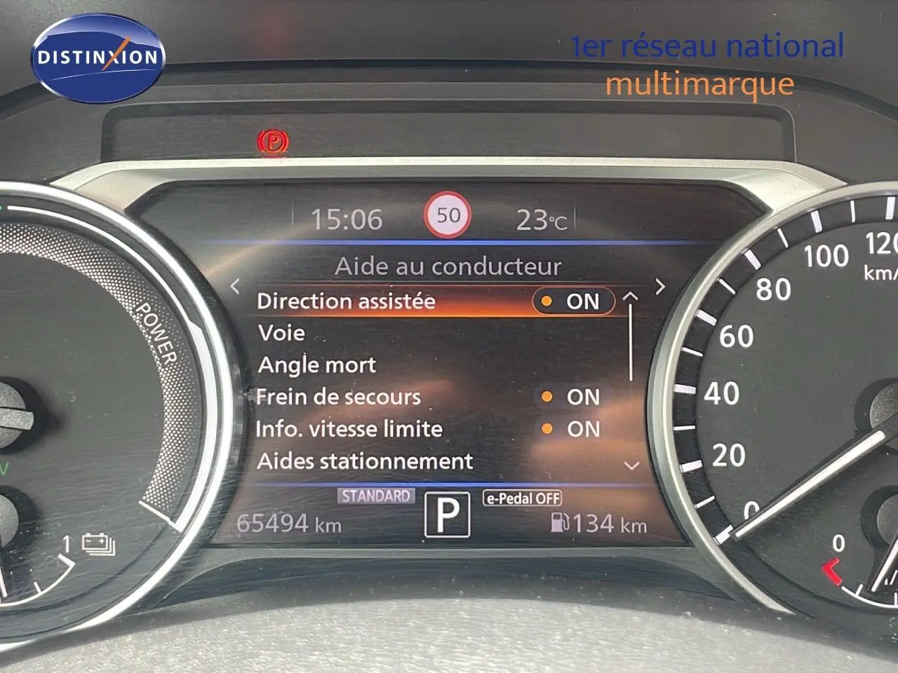 Tableau de bord numérique du Nissan Juke Hybrid 2023 affichant les aides à la conduite et la vitesse limitée à 50 km/h.
