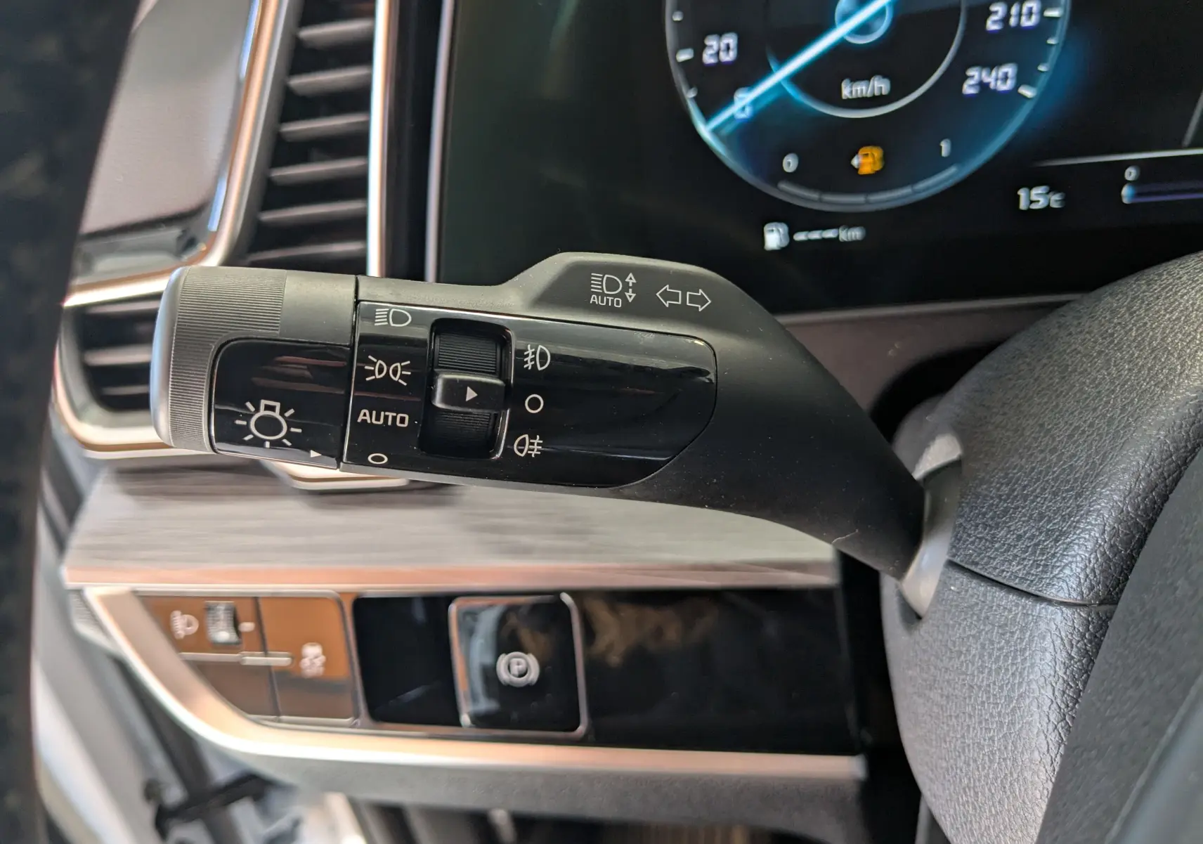 Gros plan sur la commande des phares et clignotants du tableau de bord du Kia Sportage blanc MY25.