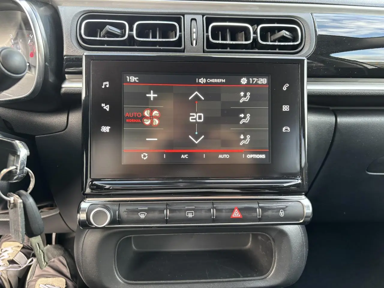 Tablette tactile centrale affichant la climatisation automatique dans l'habitacle noir d'une Citroën C3 2019.